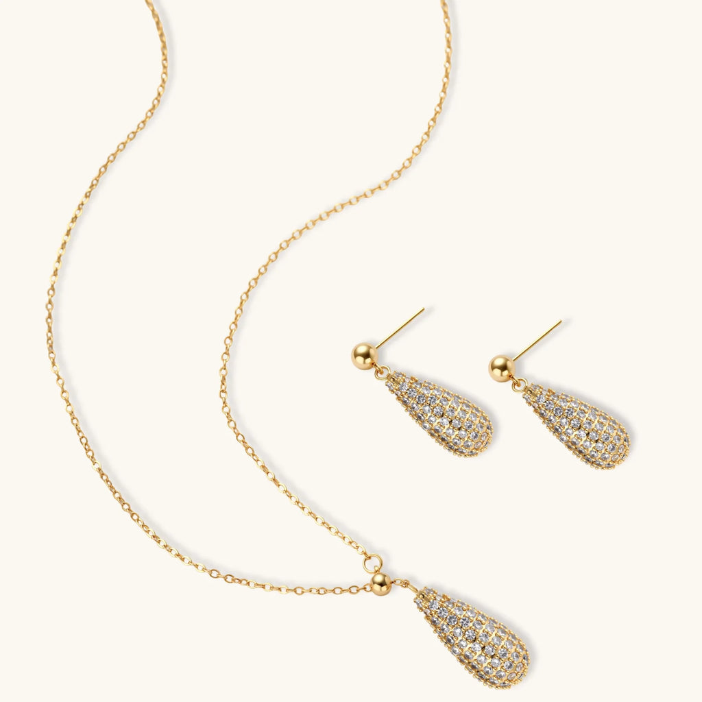 Gold necklace and earrings set on a white background