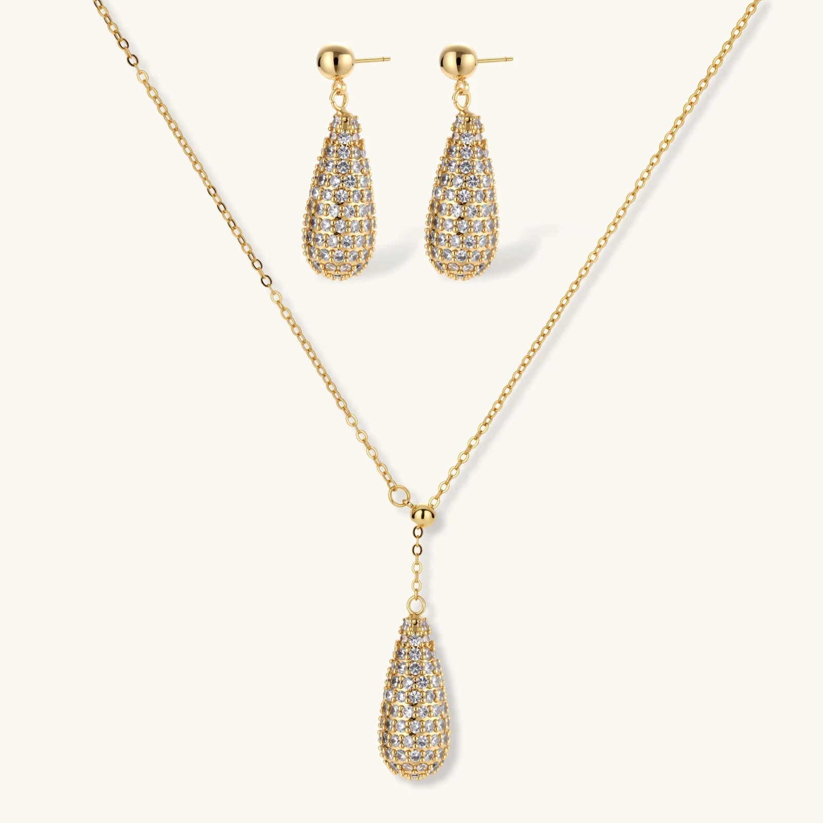 Gold teardrop necklace and earrings set on a white background