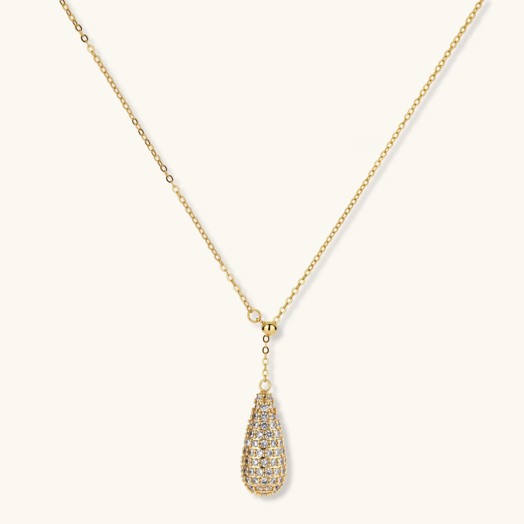 Gold necklace with a teardrop-shaped pendant on a white background