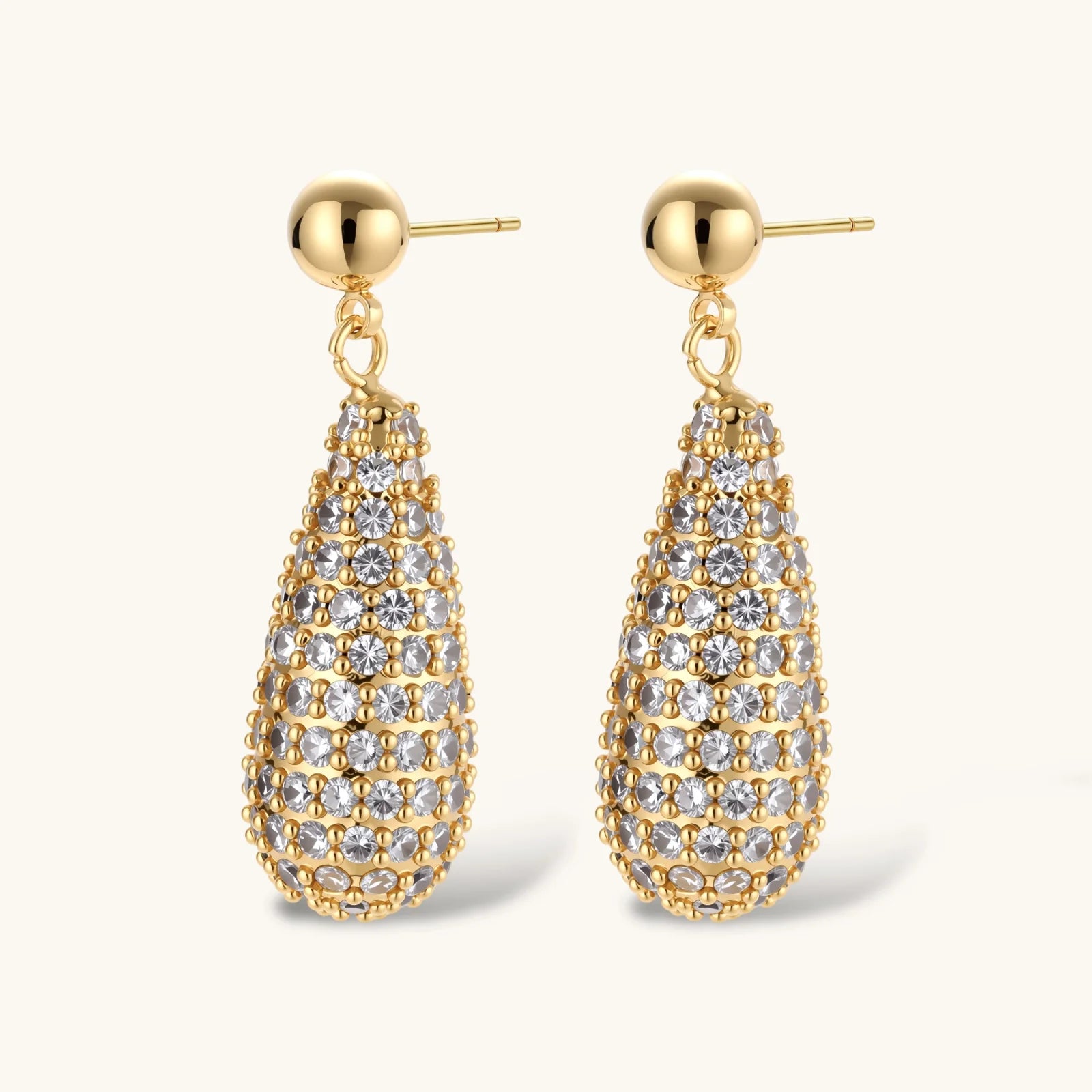 Gold teardrop earrings with clear gemstones on a white background