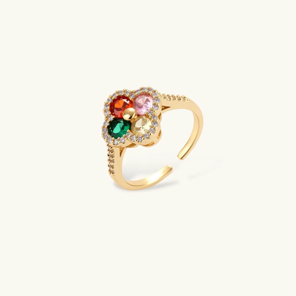 Gold ring with colorful gemstones on a white background