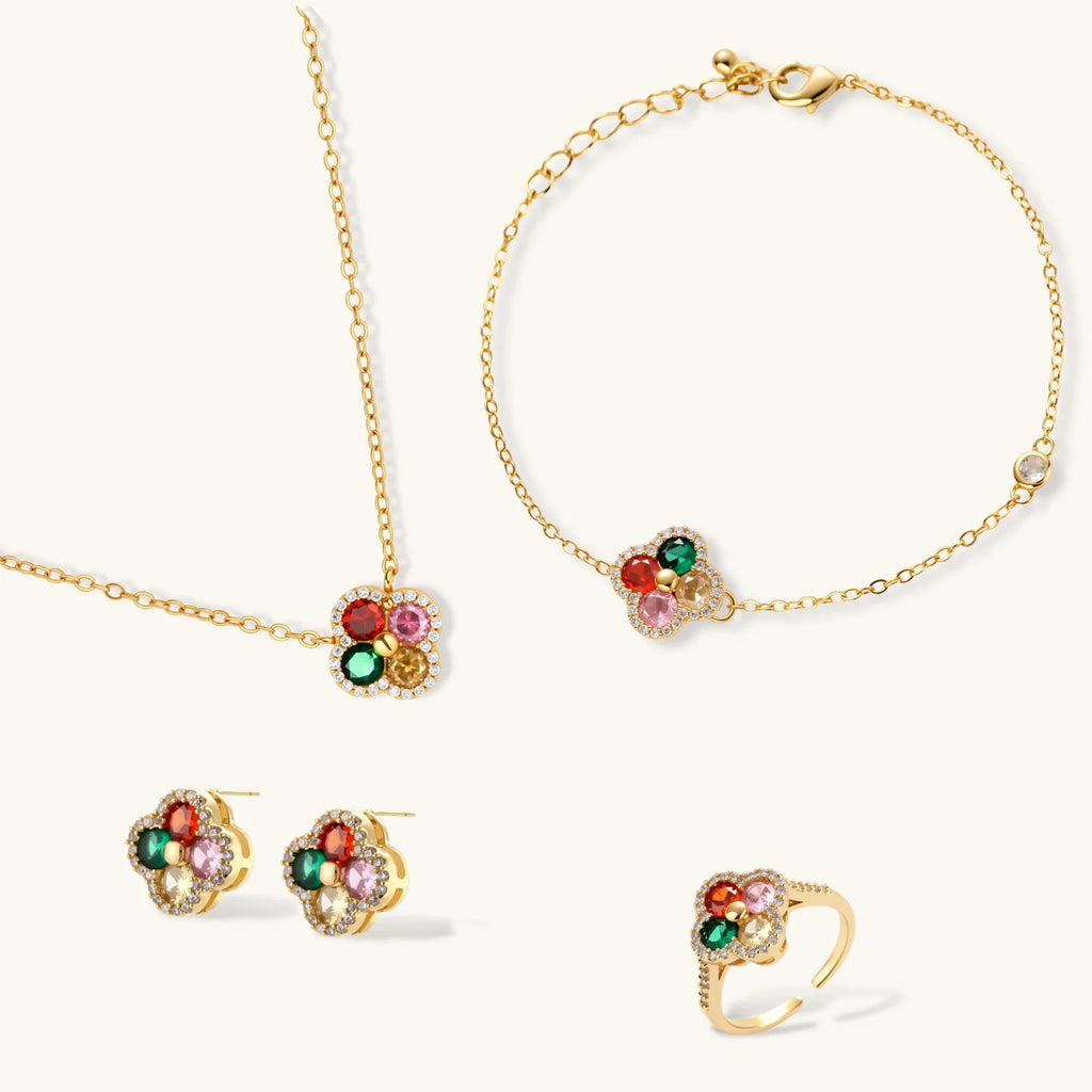 Gold jewelry set with floral designs and colorful gemstones on a white background