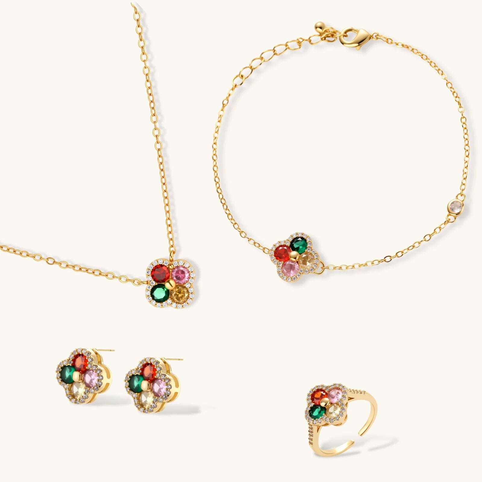 Gold jewelry set with floral designs and colorful gemstones on a white background