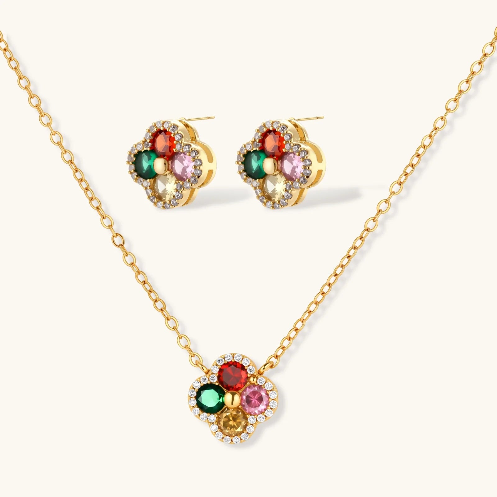 Gold necklace and earrings with multicolored gemstones on a white background