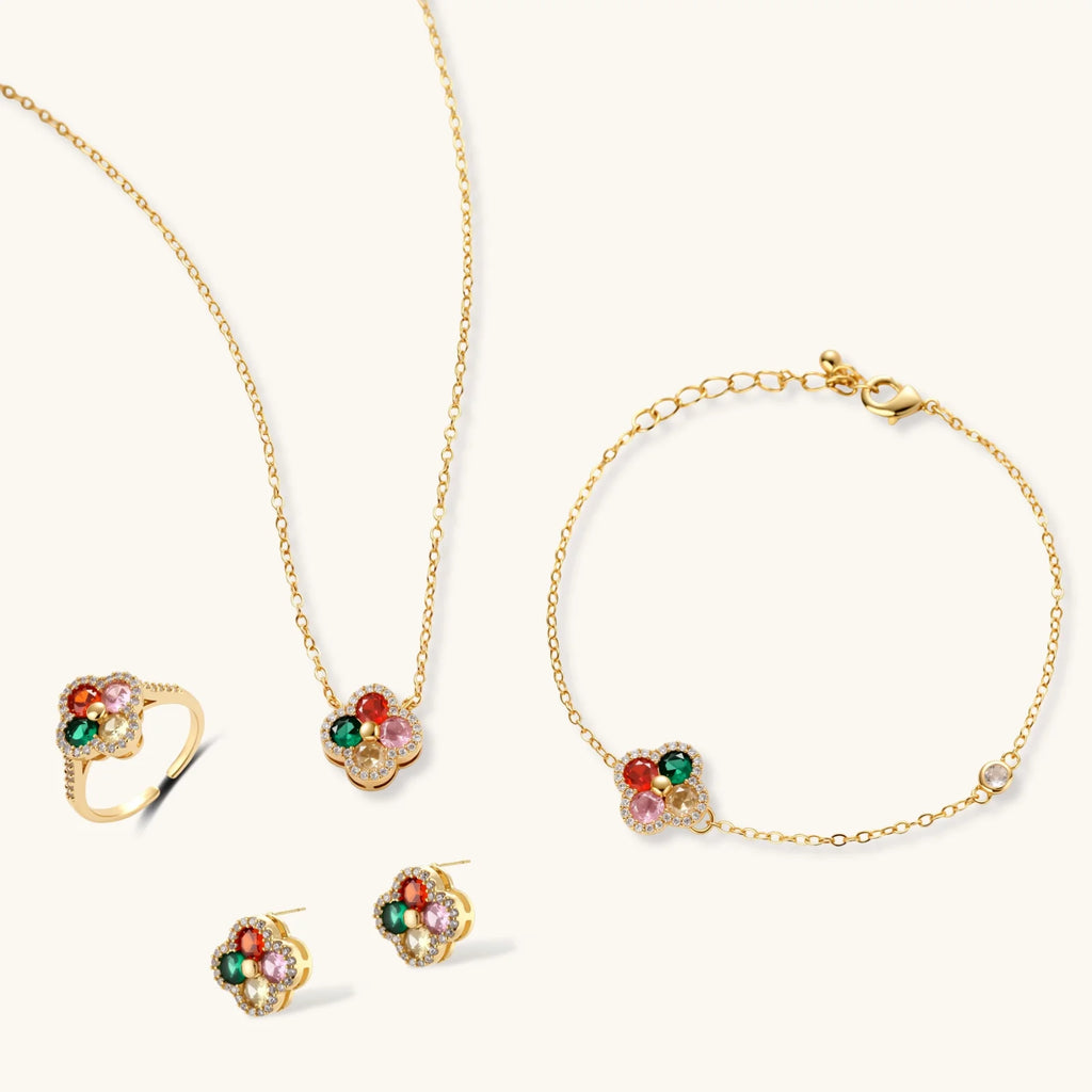 Gold jewelry set with colorful gemstones on a white background