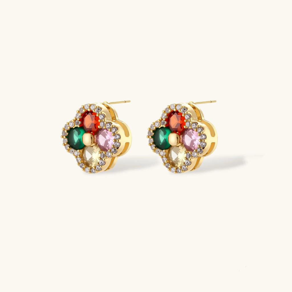 Gold earrings with colorful gemstones on a white background