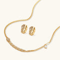 Gold geometric serpentine necklace and earrings set on a white background