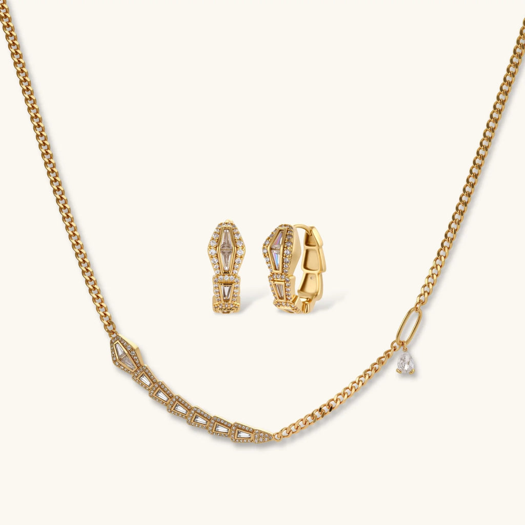 Gold geometric serpentine necklace and earrings set with zirconia sparkle on a white background