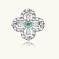 Diamante ring with a central green gemstone on a white background