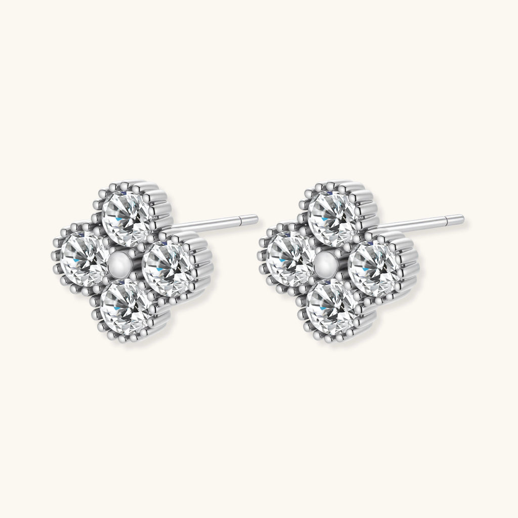 Pair of silver heart-shaped earrings with clear gemstones on a white background