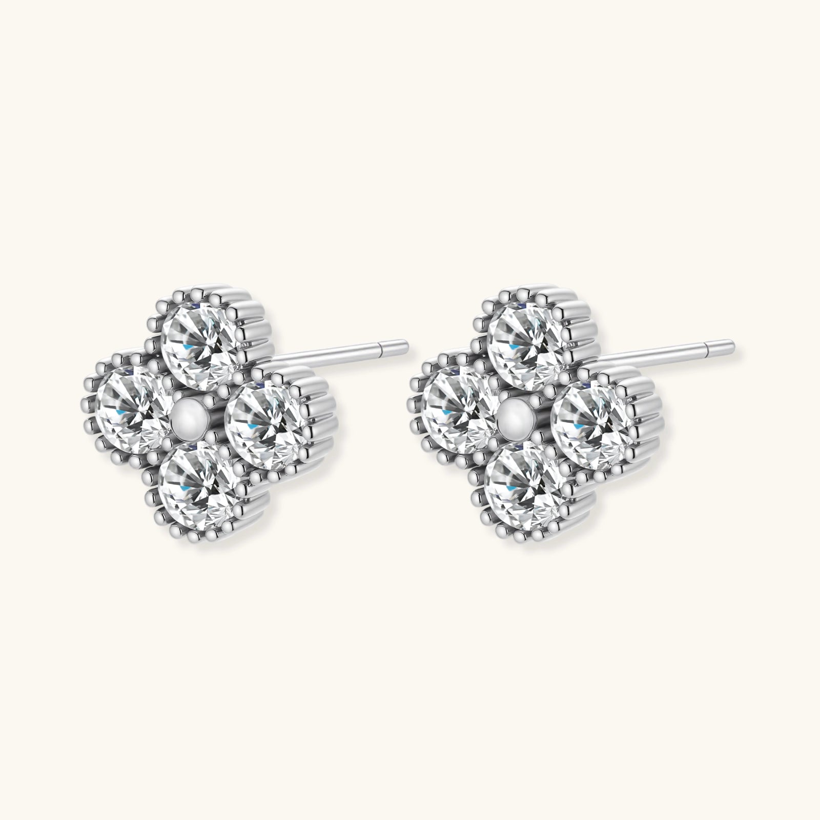 Pair of silver heart-shaped earrings with clear gemstones on a white background