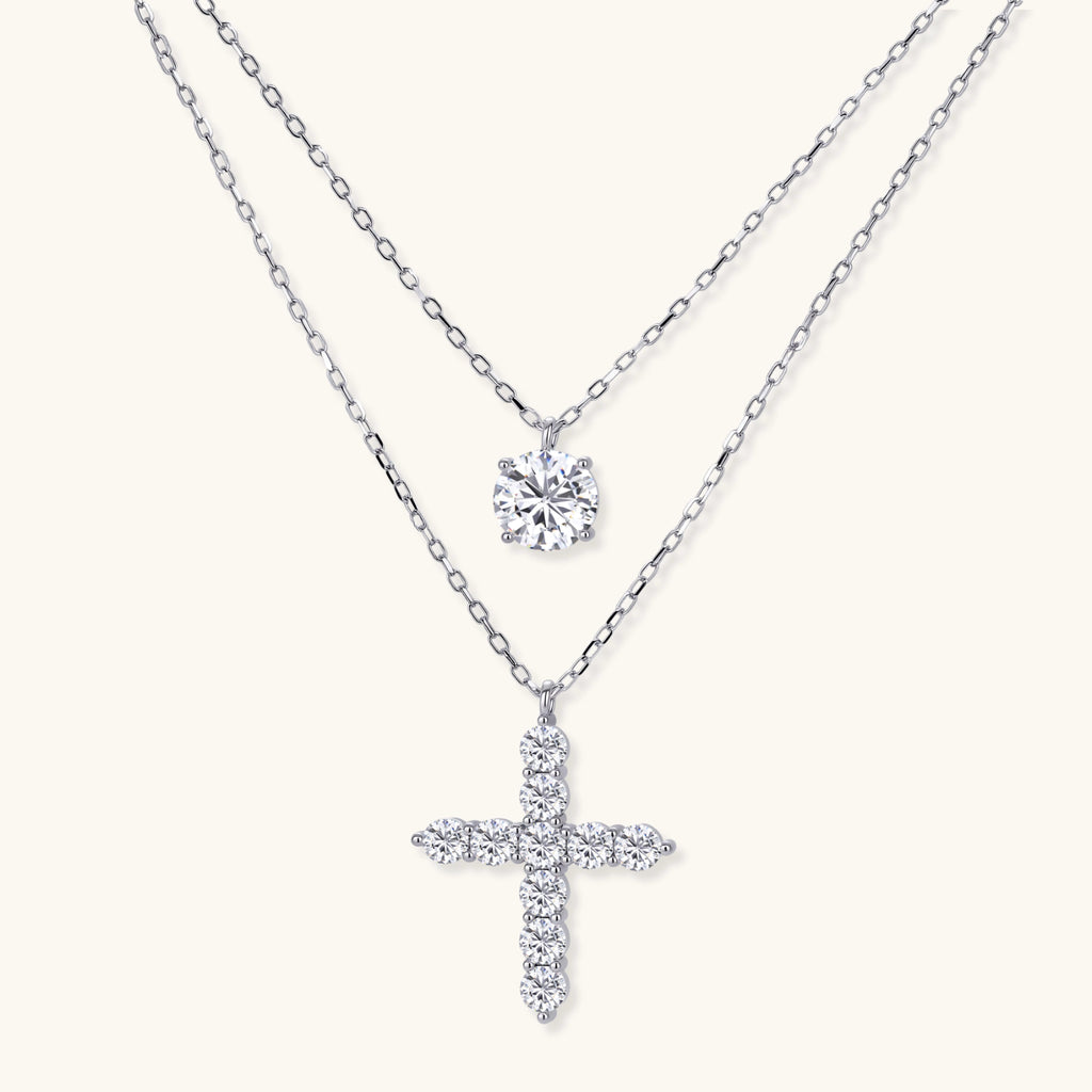 Two diamond pendants on silver chains against a white background
