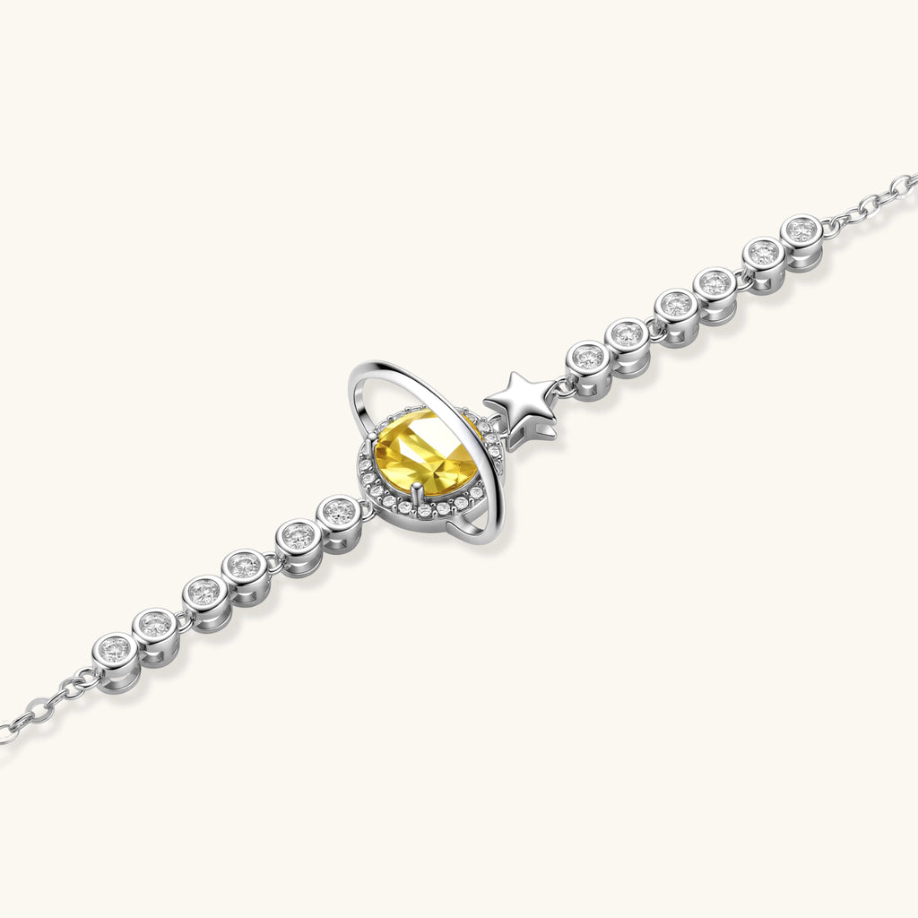 Silver bracelet with a yellow gemstone and star design on a white background
