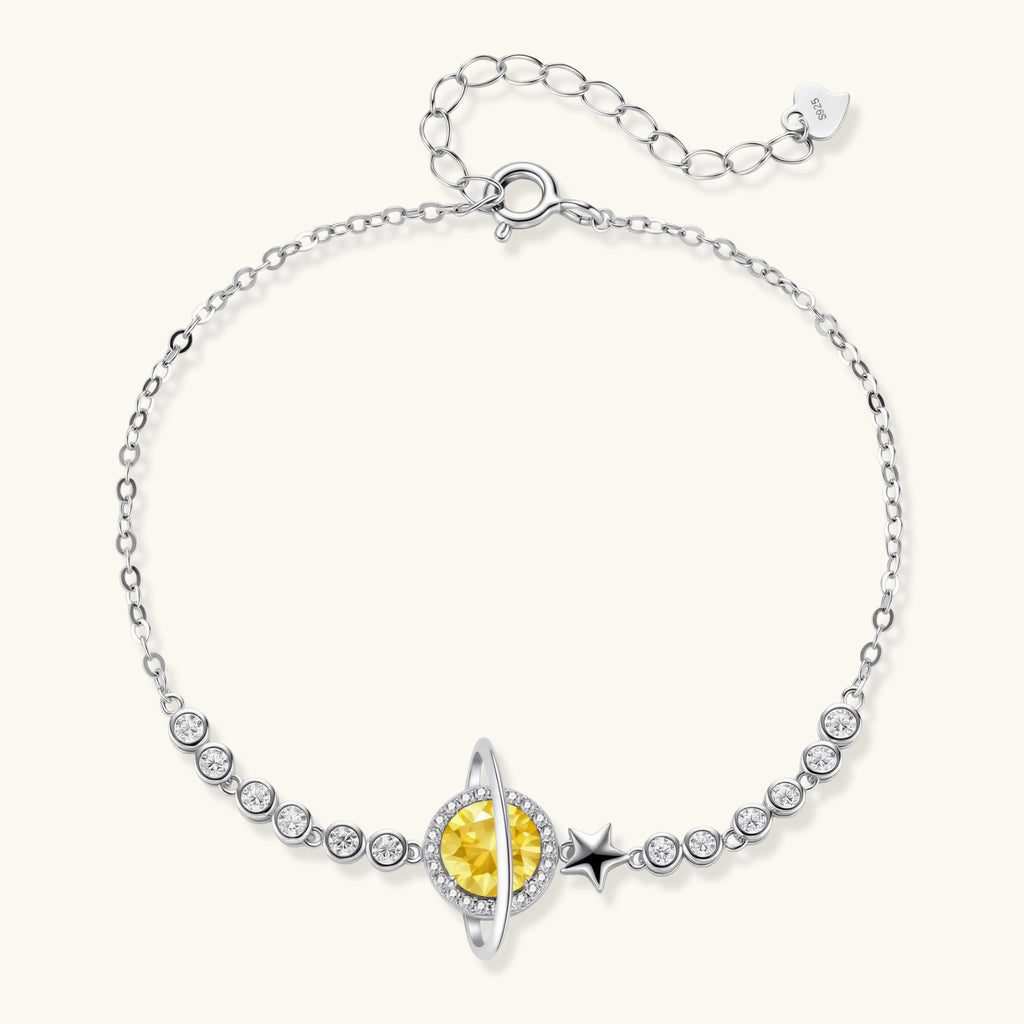 Silver bracelet with a yellow gemstone and star design on a white background