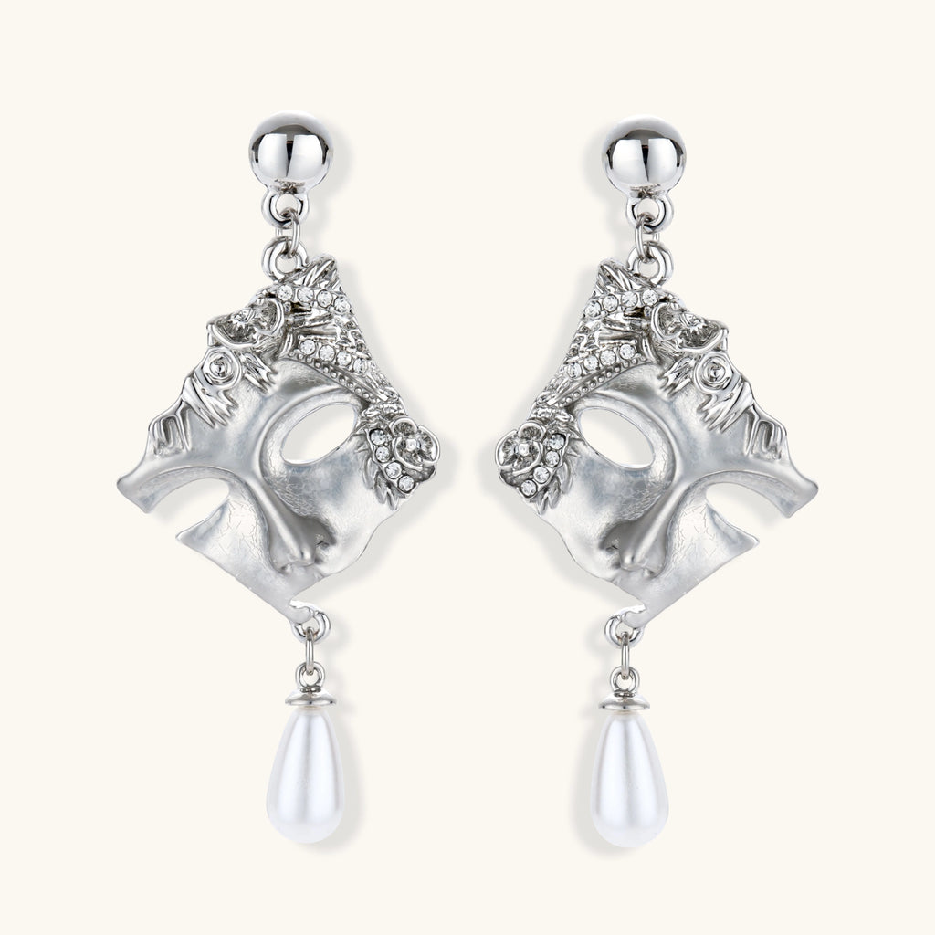 Silver earrings with intricate designs and pearl-like droplets on a white background