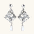 Silver earrings with intricate designs and pearl-like droplets on a white background