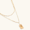 Gold necklace with a small pendant on a white background