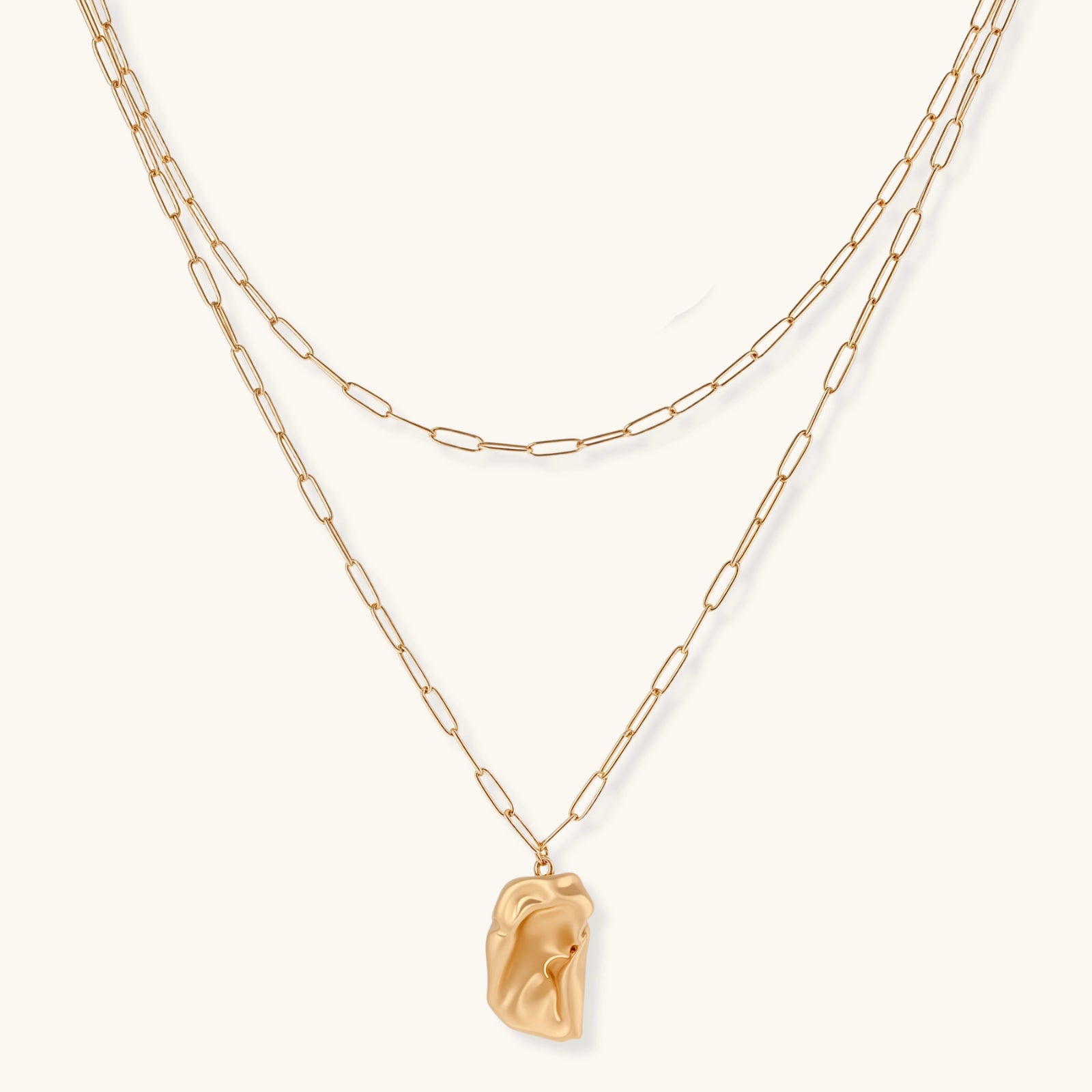 Gold chain necklace with a pendant on a white background