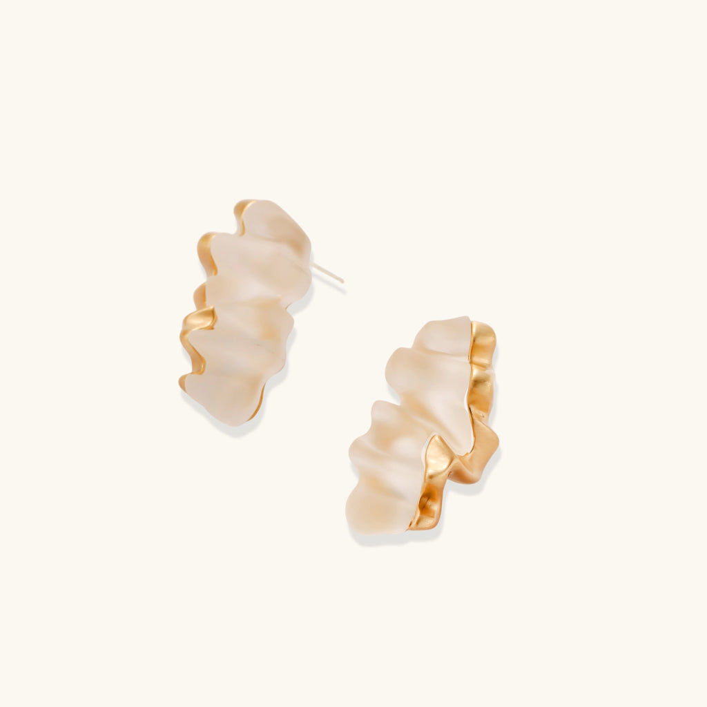Pair of gold and beige hoop earrings on a white background