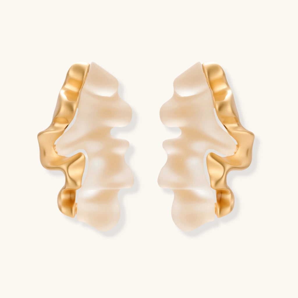 Pair of earrings with gold and beige design on a white background