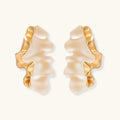 Pair of earrings with gold and beige design on a white background