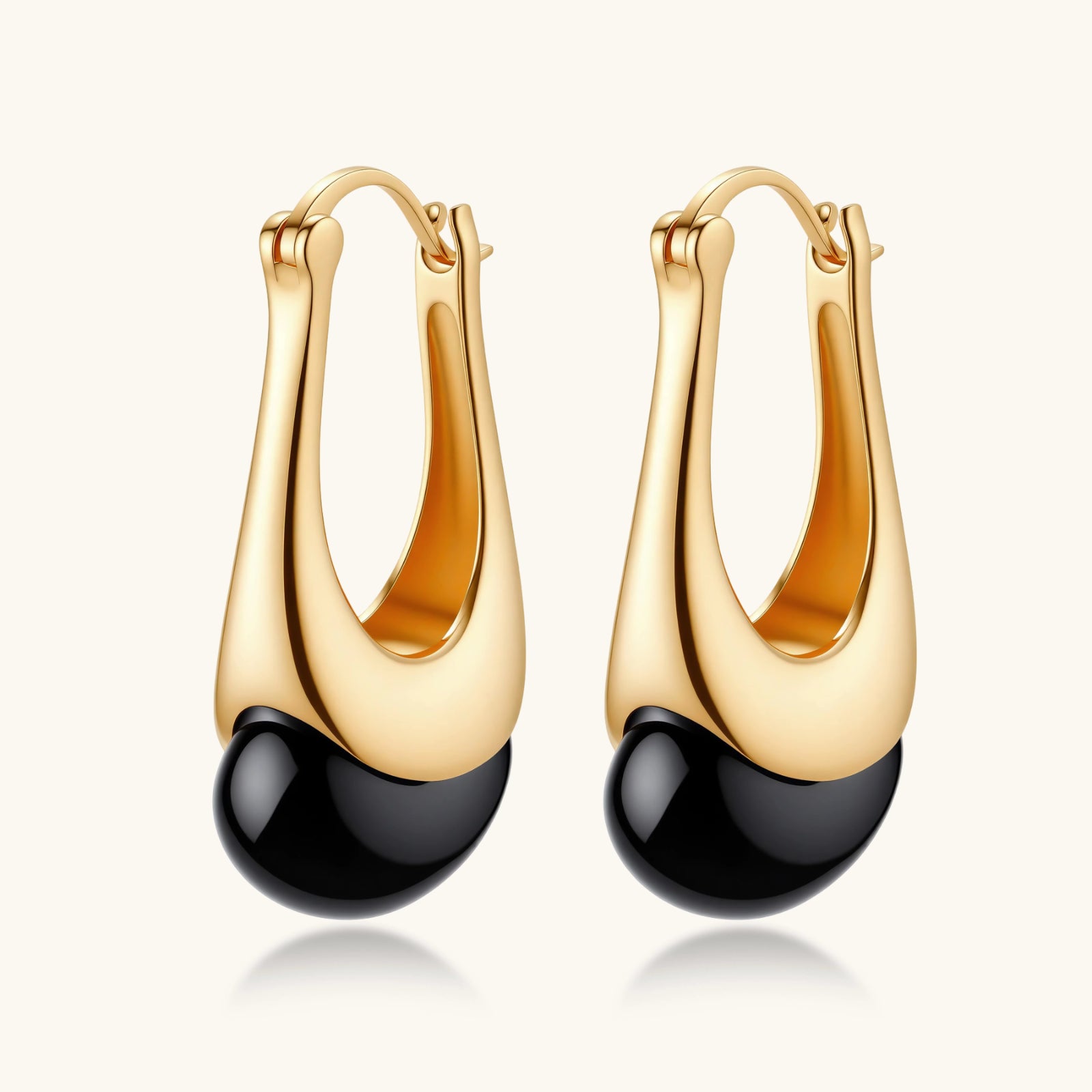 Gold hoop earrings with black beads on a white background