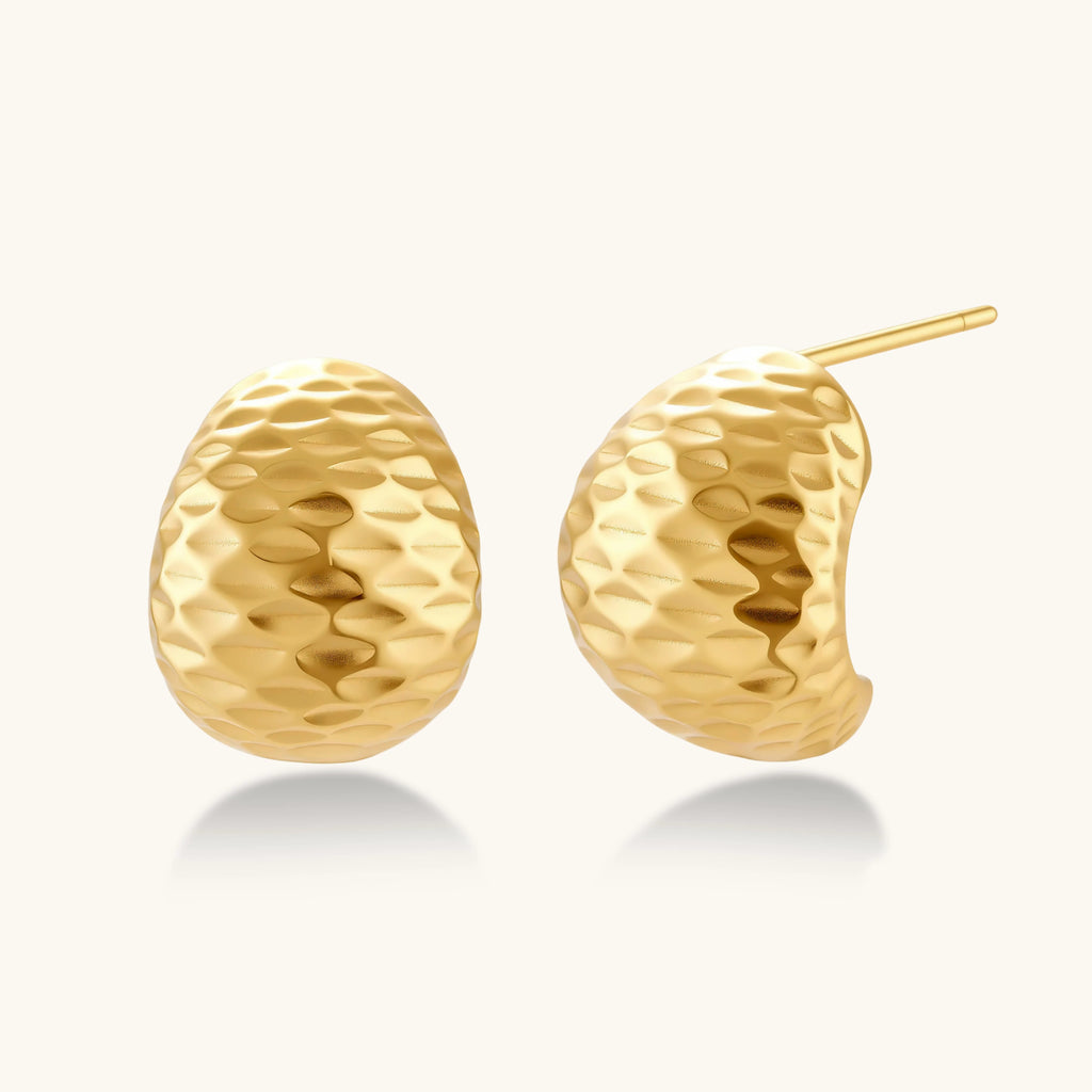 Gold earrings with textured design on a white background
