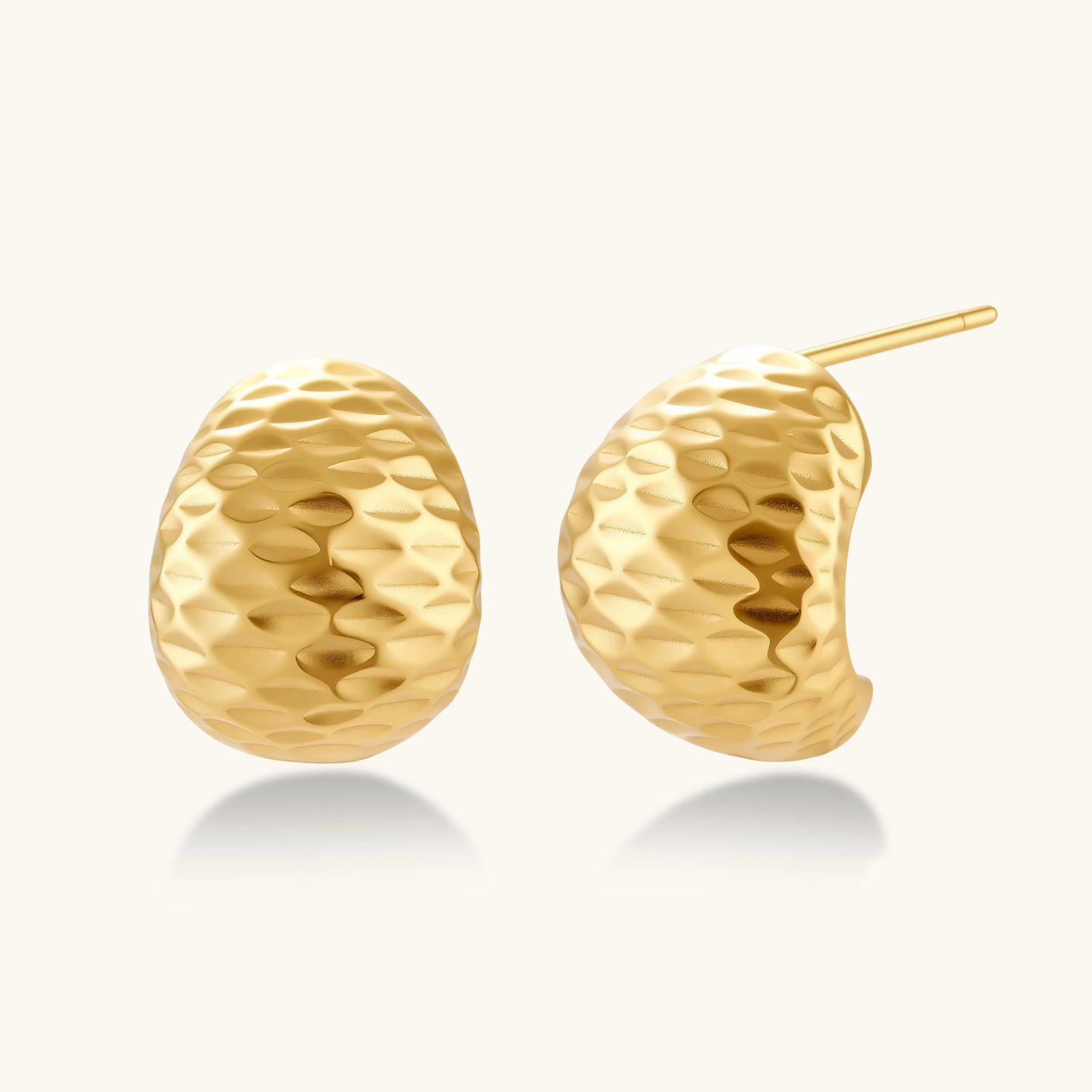 Gold earrings with textured design on a white background