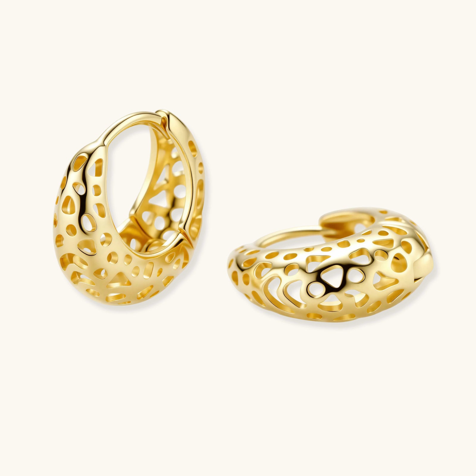 Gold hoop earrings with intricate designs on a white background