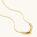Gold necklace with a curved pendant on a white background