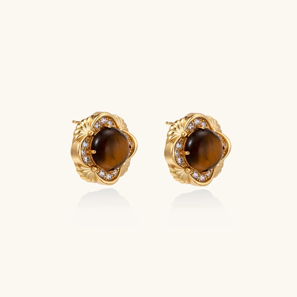 Gold earrings with brown gemstones on a white background