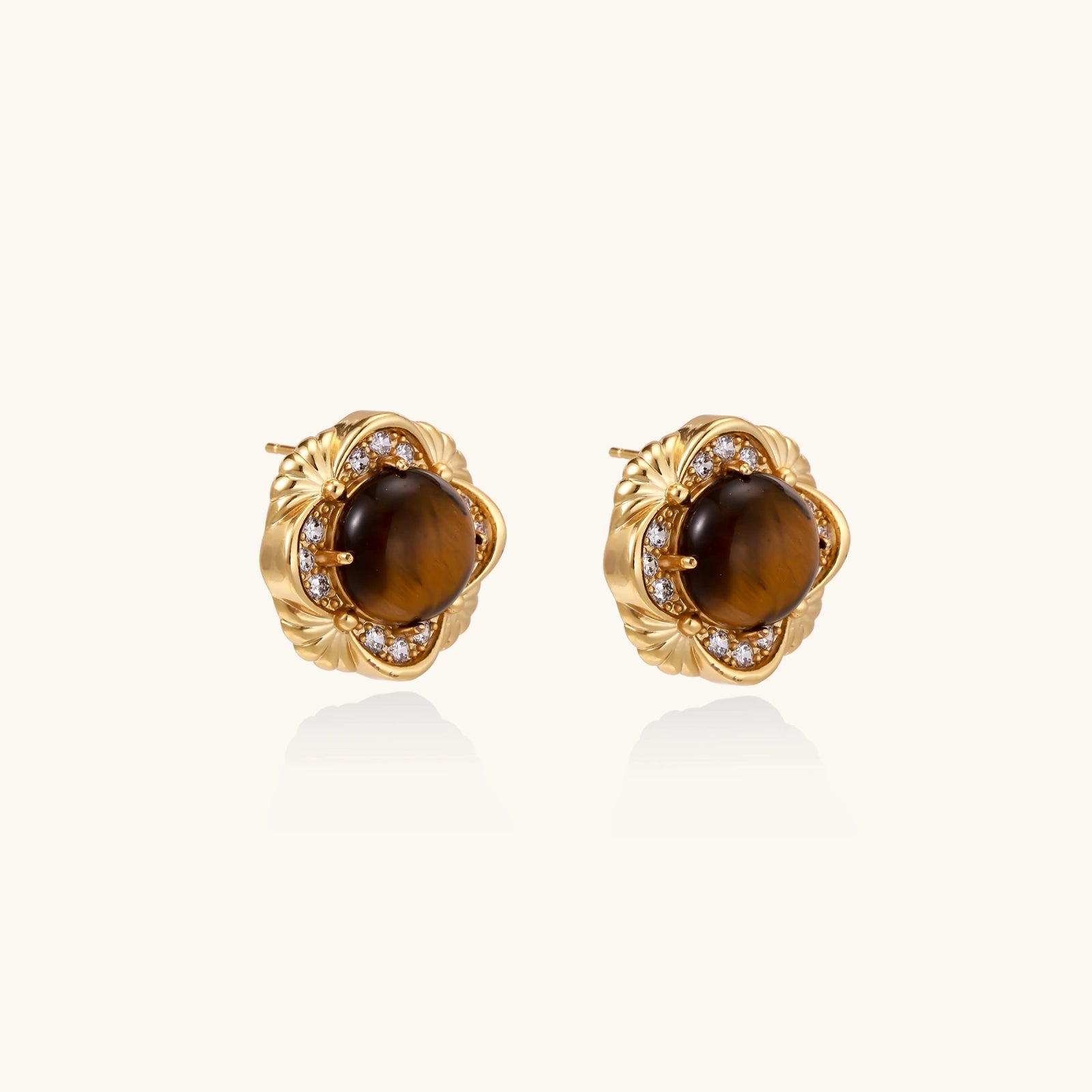 Gold earrings with brown gemstones on a white background