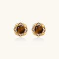 Gold earrings with brown gemstones and diamond accents on a white background
