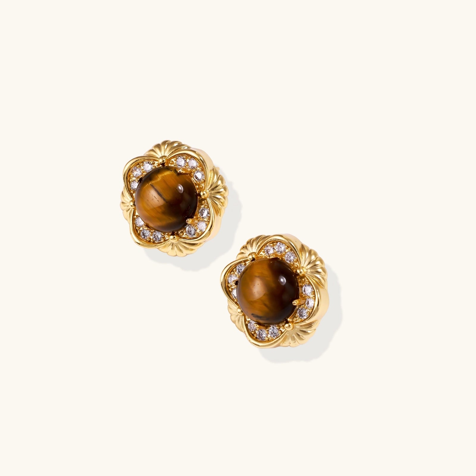Gold earrings with brown gemstones on a white background