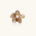 Floral brooch with pearl center on a white background