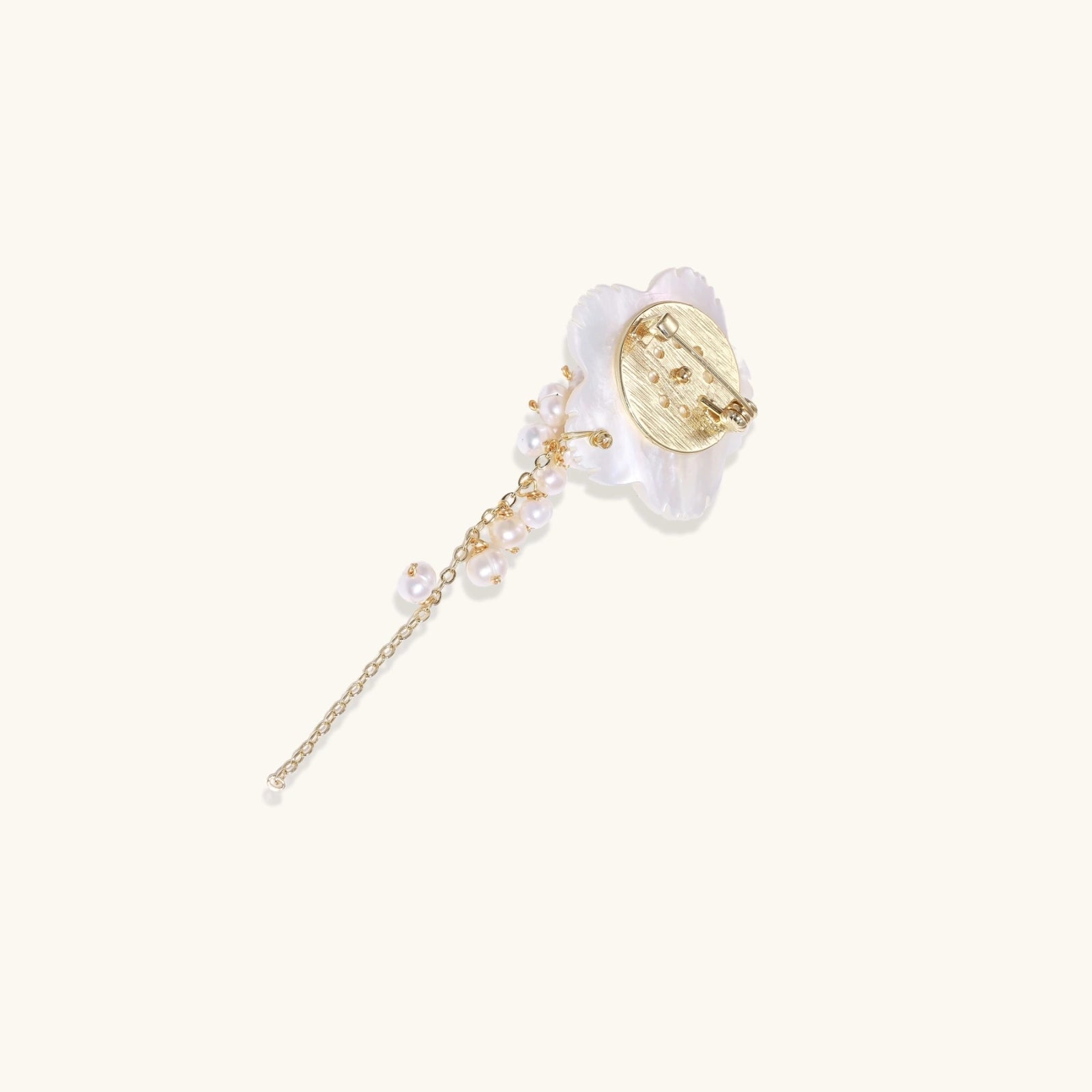 Decorative hairpin with floral design and pearl chain on a white background