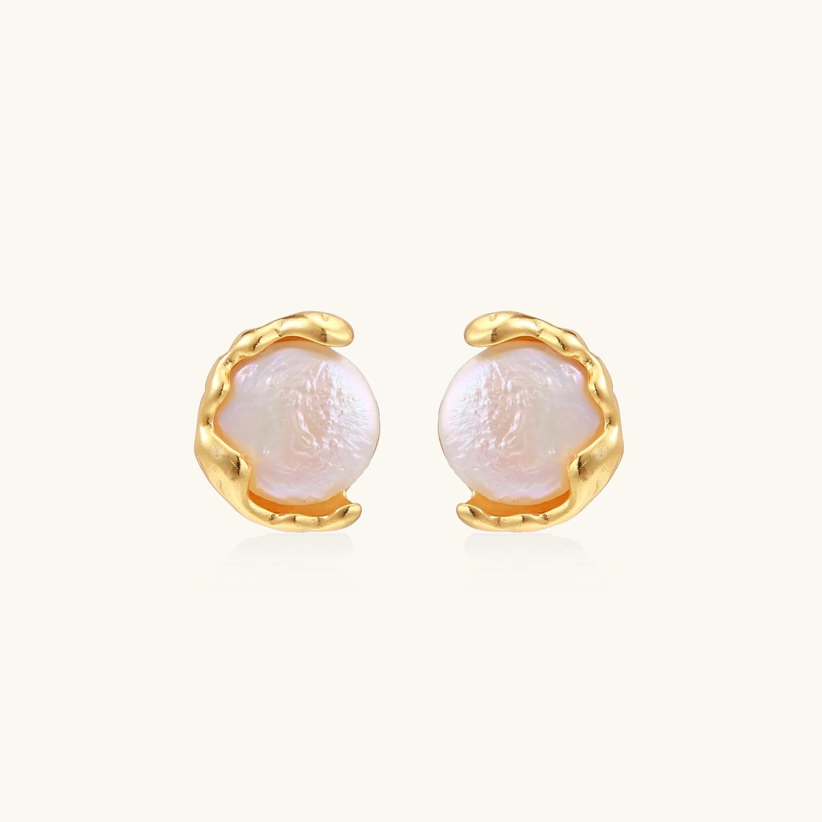 Pair of pearl earrings with gold settings on a white background
