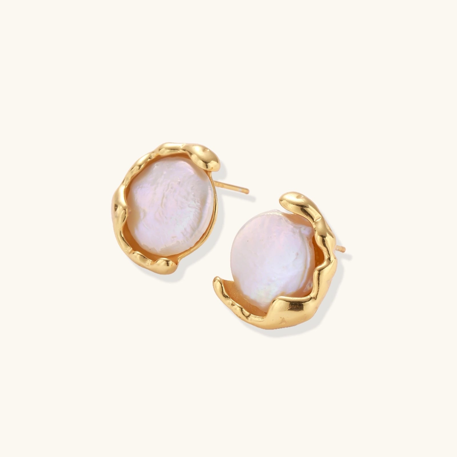Gold earrings with pink stone centers on a white background