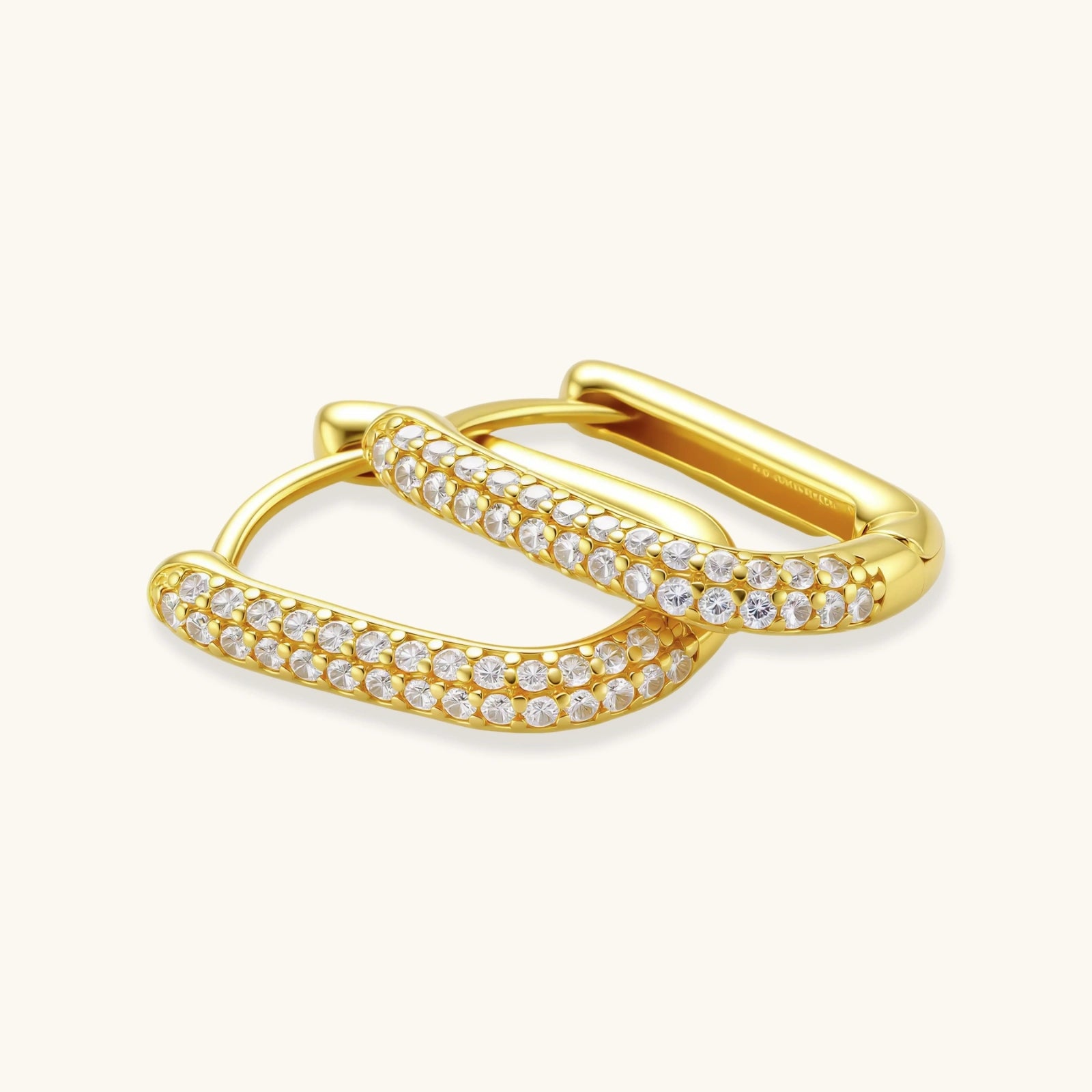 Gold huggie earring with clear gemstones. 