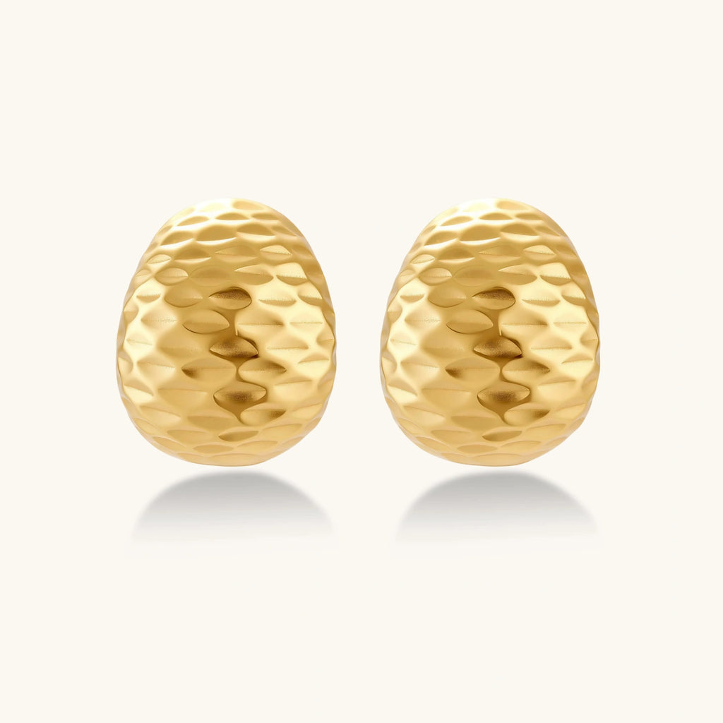 Pair of gold textured earrings on a white background