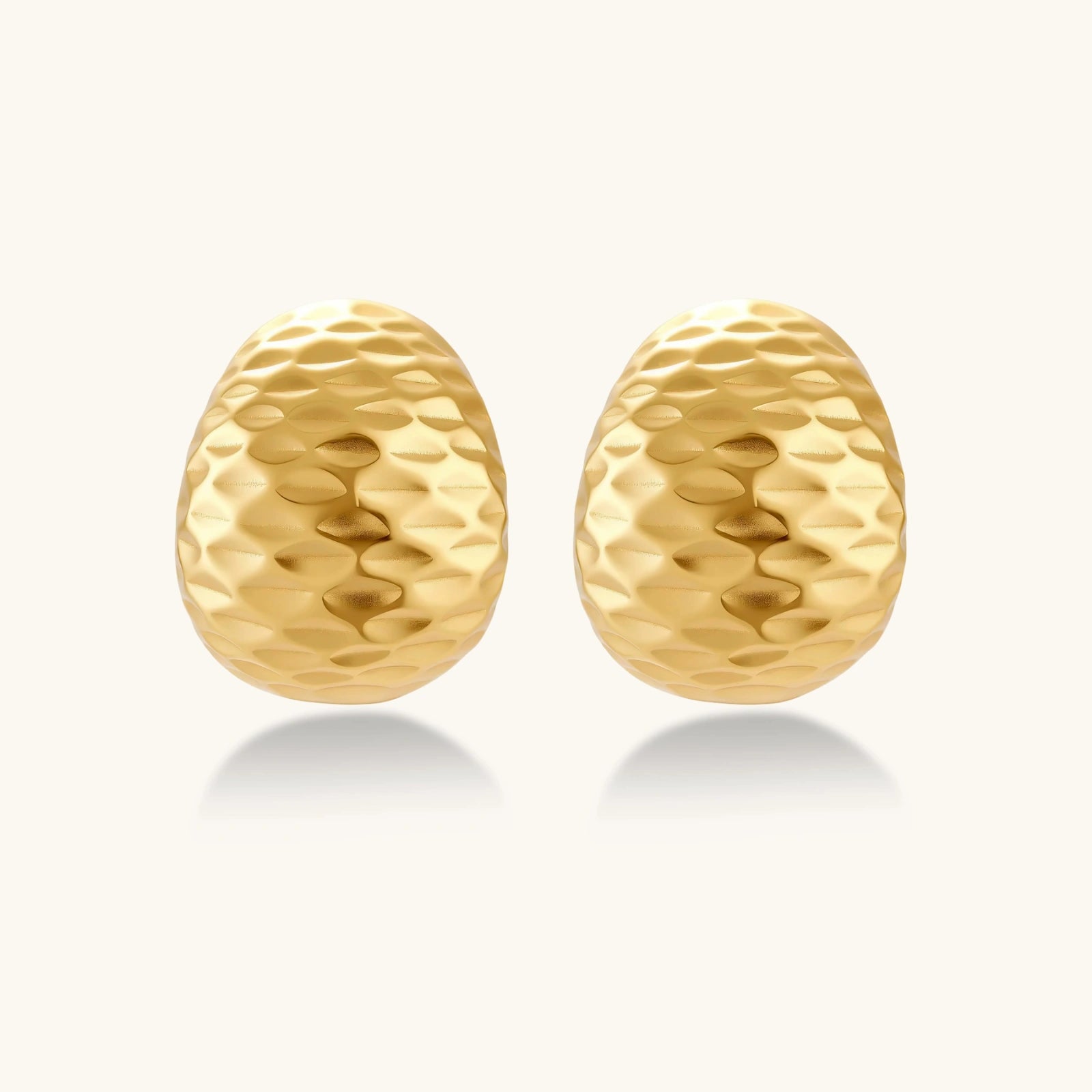 Pair of gold textured earrings on a white background