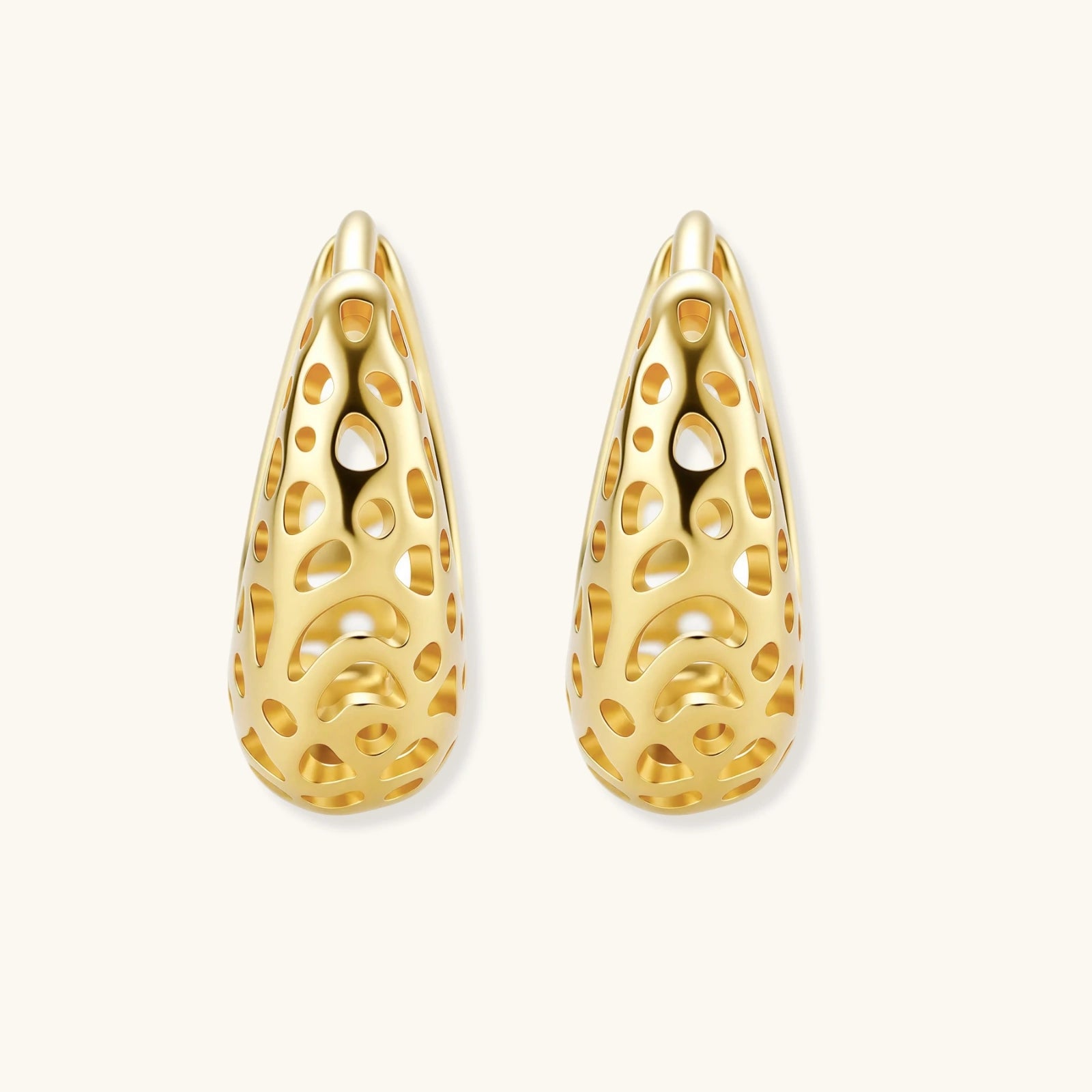 Gold teardrop-shaped earrings with intricate designs on a white background
