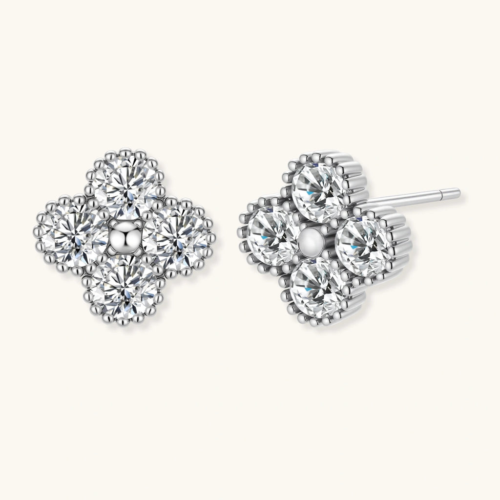Pair of clover-shaped diamond stud earrings on a white background