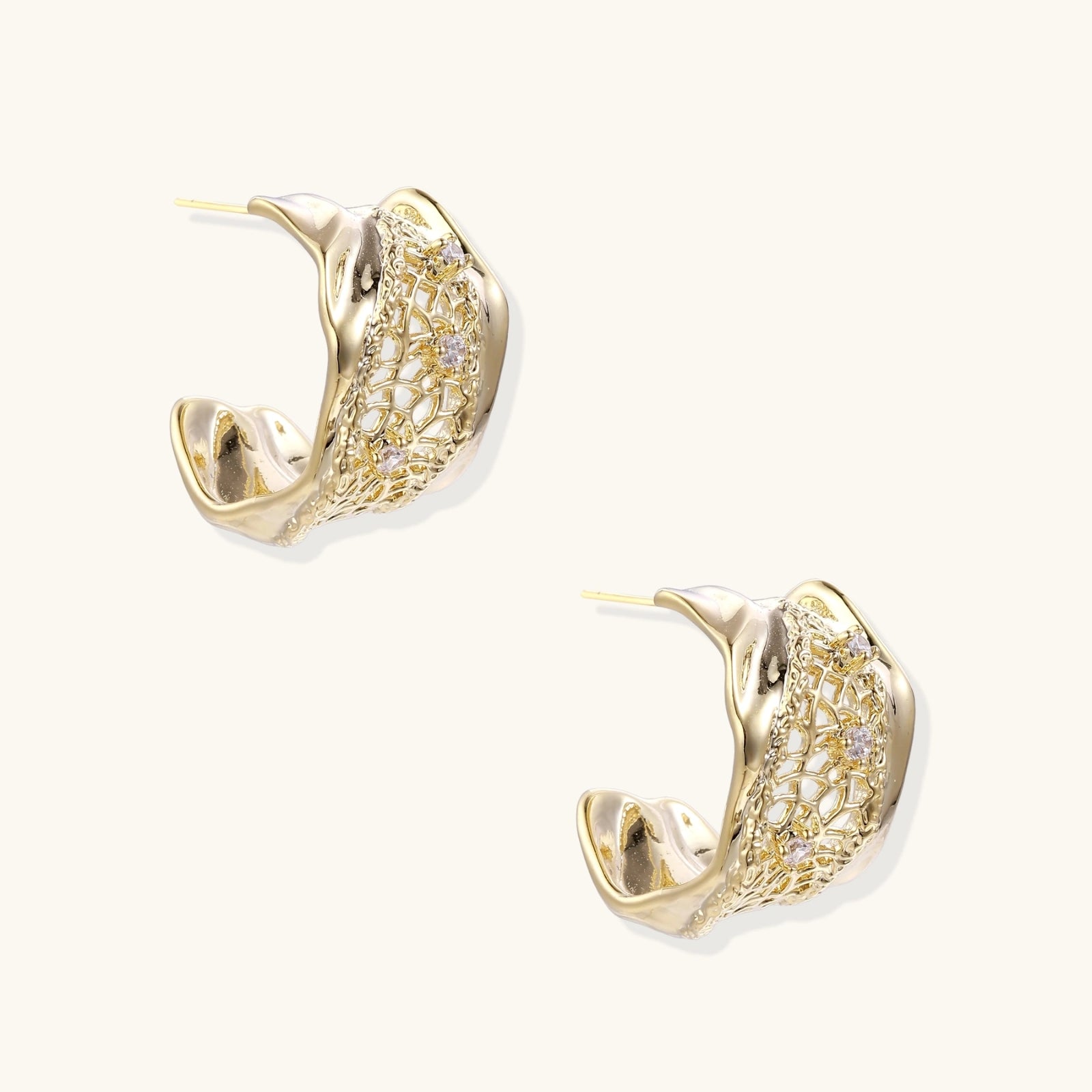 Gold hoop earrings with intricate designs on a white background