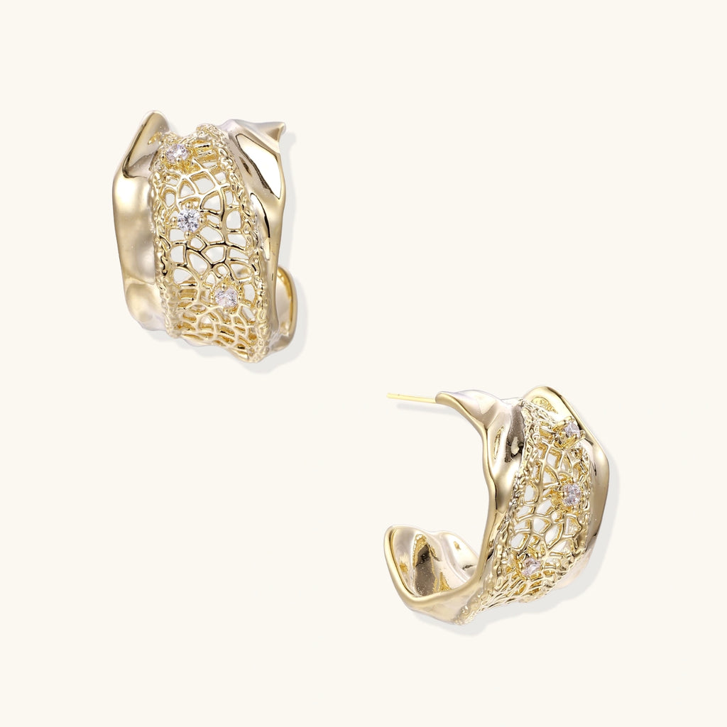Gold hoop earrings with intricate designs on a white background