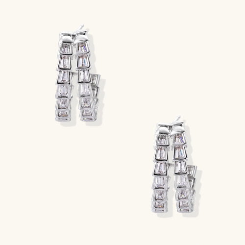 Pair of silver earrings with clear gemstones on a white background