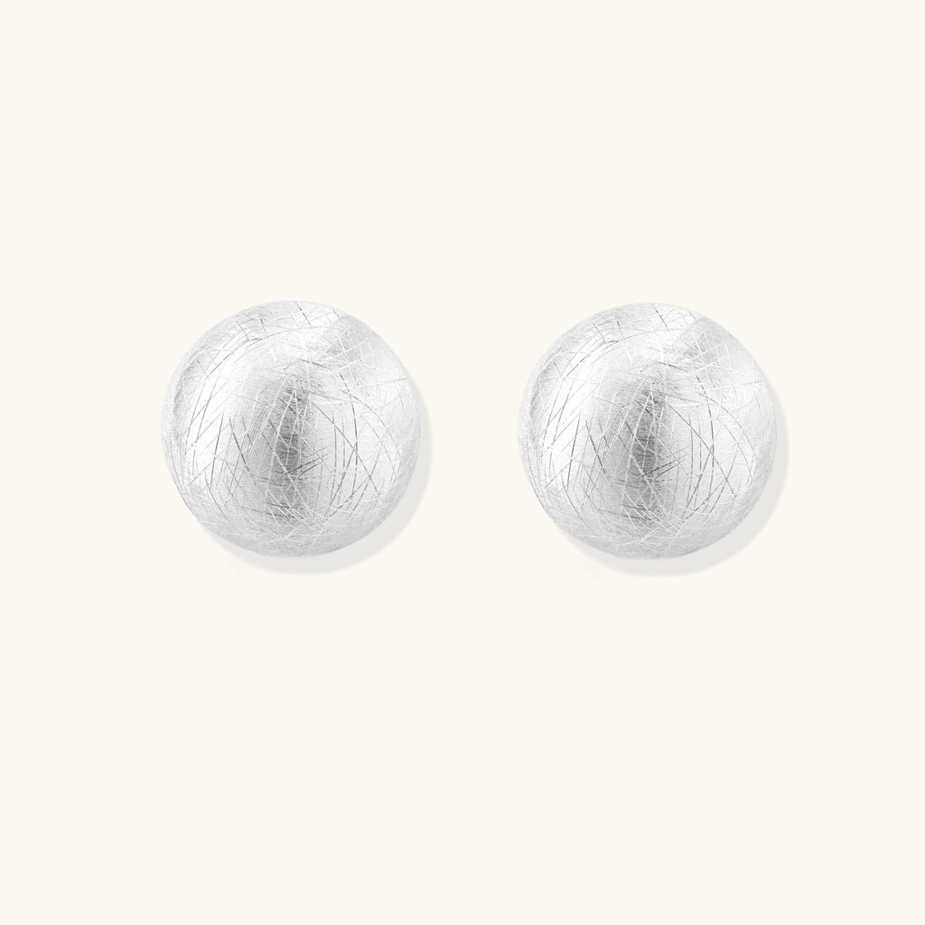 Pair of silver round earrings on a white background