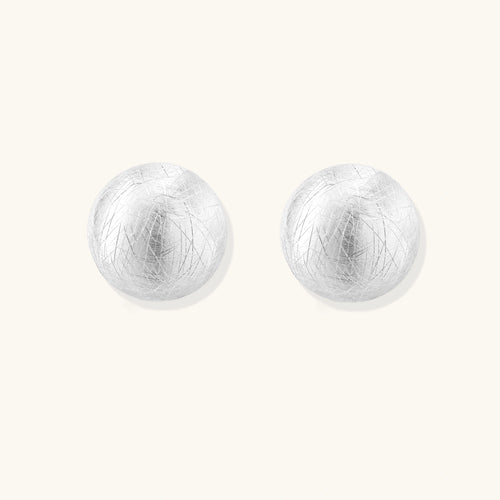 Pair of silver round earrings on a white background