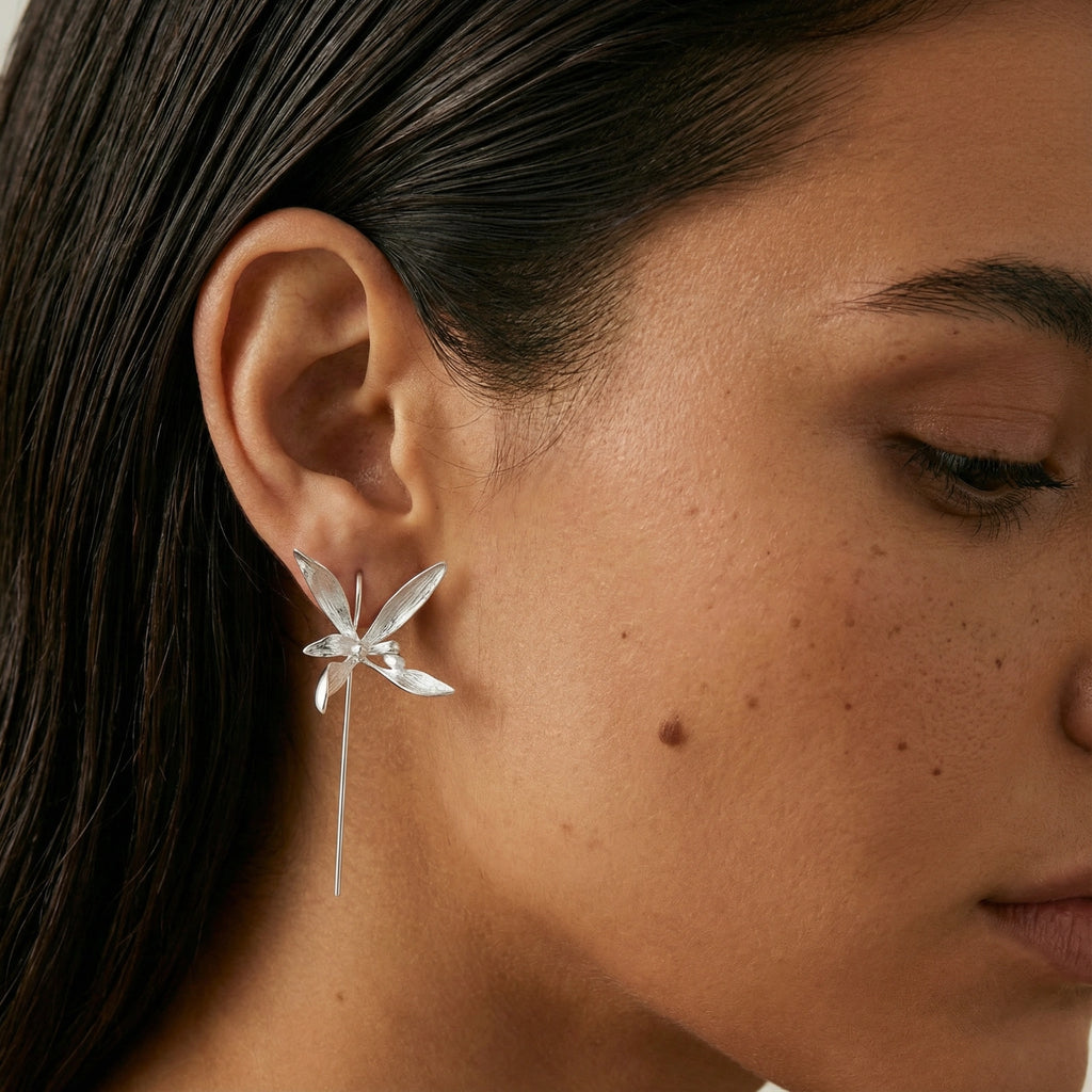 Close-up of a woman wearing a sterling silver floral threader earring