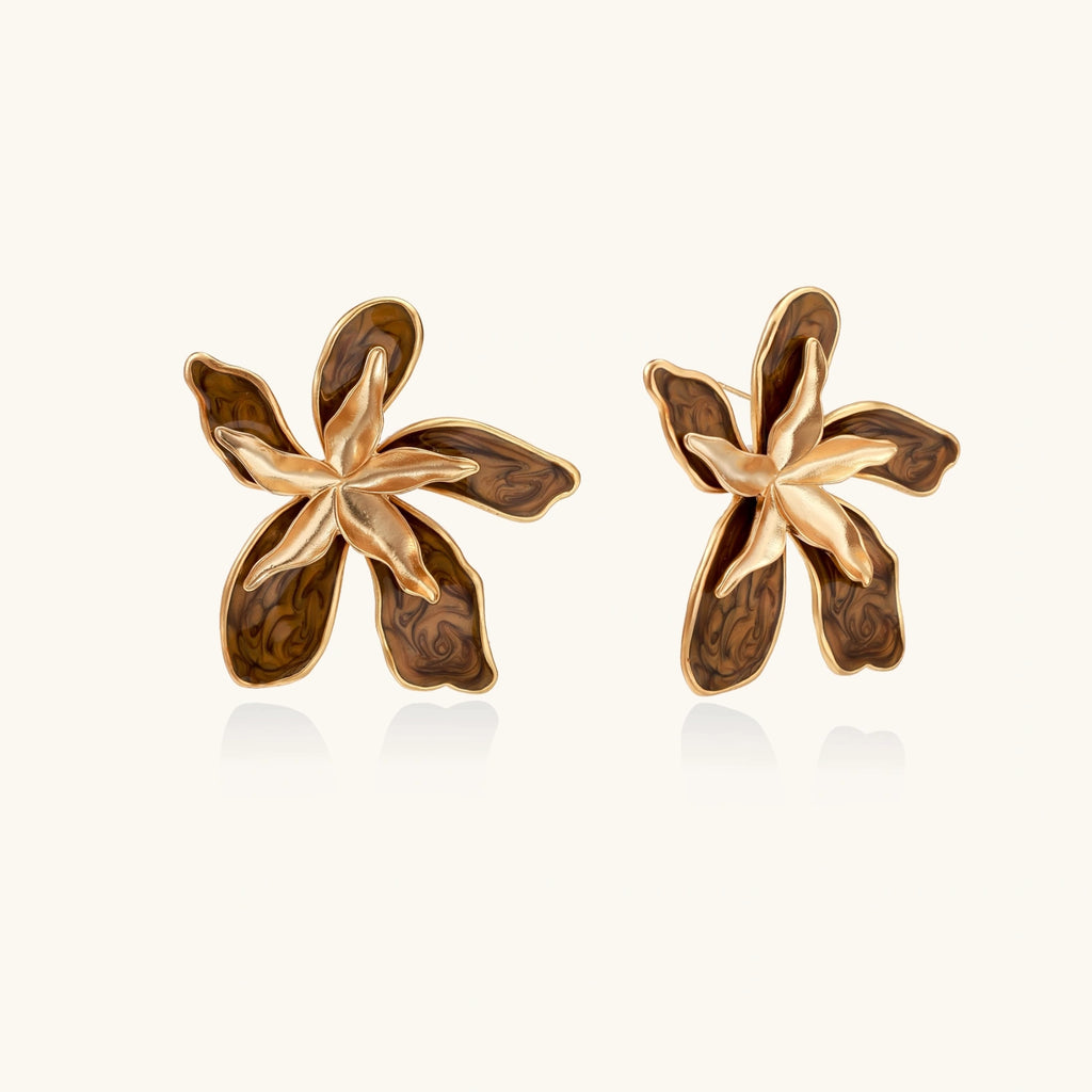 Pair of gold and brown floral earrings on a white background